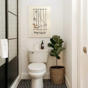 Bring a smile to your space with this Too Silly goose art print! A funny, minimalist illustration featuring a cheeky goose behind bars for being “too silly.” Perfect for adding personality to your home, office, or gallery wall.
This quirky silly goose animal print makes a wonderful gift for friends who love humor, cottagecore whimsy, or modern minimalist art. Designed to brighten up any corner and spark joy daily.