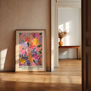 May include: A framed poster with a colorful floral design in shades of pink, yellow, blue, and green. The poster has the text "BRITISH COUNTRYSIDE" and "BLOSSOMS WHISPER RURAL TALES".