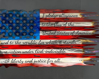 May include: A metal American flag with a distressed, torn look. The Pledge of Allegiance is inscribed on the flag in black lettering.