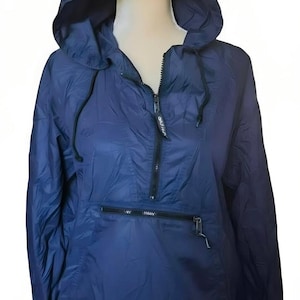 May include: A navy blue hooded anorak jacket with a half-zip closure and a front pocket. The jacket has a drawstring hood and a lightweight, water-resistant design. The jacket is displayed on a mannequin.