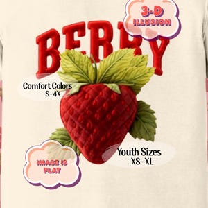 May include: Cream-colored t-shirt with a large red "BERRY" graphic and a 3D strawberry illustration. The shirt includes text that says "Comfort Colors S-4X" and "Youth Sizes XS-XL". The image also says "IMAGE IS FLAT".