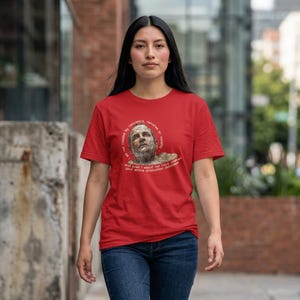 Op de afbeelding: Rood t-shirt met een portret van een man en de tekst: "niet veroorzaakt door geweten, berouw of moraal en zelfs ik zou uw hele productie database niet hebben verwijderd."