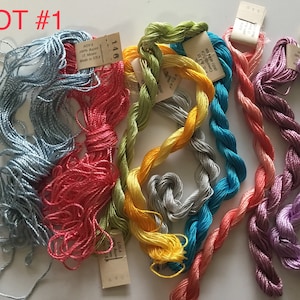 May include: Lot #1 of embroidery floss in a variety of colors, including blue, red, green, yellow, gray, turquoise, and purple. The floss is wound into skeins and labeled with the brand name and color number.