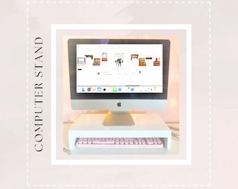 May include: White computer stand with a pink keyboard. The stand raises the computer monitor to a more ergonomic height.