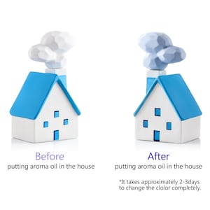 May include: Two ceramic house-shaped aroma diffusers. The houses are white with blue roofs and chimneys, with a cloud-shaped top. Text reads "Before" and "After" putting aroma oil in the house. The text also says it takes 2-3 days to change the colour.