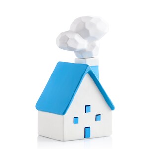 May include: A white ceramic house ornament with a blue roof and chimney, and a cloud-shaped smoke plume. The house has four blue square windows and a blue door. The ornament is on a white background.