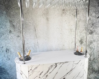 May include: White marble bar cart with a champagne glass rack, two ice buckets, and the word "Champagne" printed on the front.