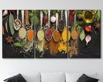 May include: A black background with various spices in silver spoons. The spices include red pepper flakes, cumin, turmeric, coriander, and black peppercorns. There are also fresh herbs, garlic cloves, and a small bowl of olive oil.
