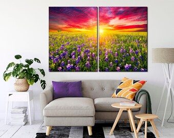 May include: A split canvas print featuring a vibrant sunset over a field of purple wildflowers. The sky is a mix of red, orange, and yellow, with clouds reflecting the warm light. The wildflowers are in full bloom, creating a beautiful and colorful scene.