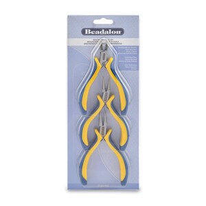 Può includere: Un set di tre pinze per gioielli Beadalon ergonomiche con manici gialli e blu. Le pinze sono confezionate in una confezione blister di plastica trasparente con il logo Beadalon e il testo "Ergonomic Plier Kit".