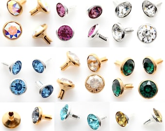 May include: Assortment of colorful crystal rhinestones with gold and silver settings. The rhinestones are in various colors, including blue, green, pink, and clear.