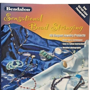 Può includere: Un libro intitolato "Sensational Bead Stringing" con uno sfondo blu e una varietà di gioielli in perle colorate in mostra. Il libro presenta 40 progetti di gioielli eleganti, suggerimenti e tecniche di base, istruzioni facili da seguire e fotografie dettagliate. Include anche il testo "Usa i fili Beadalon® per creare gioielli sensazionali!"