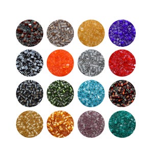 Può includere: Una collezione di sedici disposizioni circolari di perline quadrate di vetro in vari colori. Le perline sono nelle tonalità di rosso, arancione, argento, oro, verde, blu e viola. Le perline sono esposte su uno sfondo bianco.