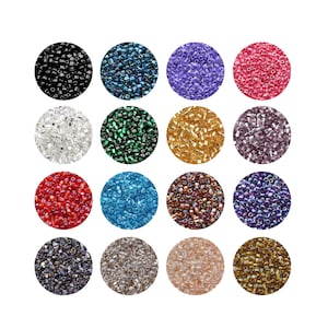 Pode incluir: Uma coleção de contas de sementes em várias cores, incluindo preto, verde-azulado, roxo, rosa, branco, verde, dourado e vermelho. As contas são dispostas em padrões circulares, mostrando suas diversas tonalidades e texturas, perfeitas para fazer joias e artesanato.