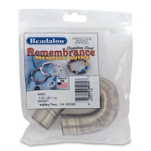 May include: A pack of silver stainless steel memory wire, labelled "Remembrance Memory Wire" and "1 oz. (28.3 g) Bright". The pack is made in the USA.