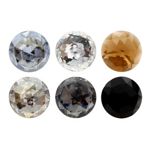 May include: Six round, faceted glass beads in various colours, including black, brown, grey, and clear.