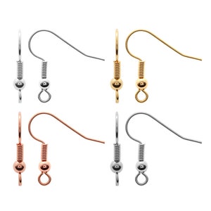 Op de afbeelding: Set van zes oorhaken in drie verschillende afwerkingen: zilver, goud en roségoud. Elke haak heeft een veerbelaste sluiting en een kleine bal aan het uiteinde.