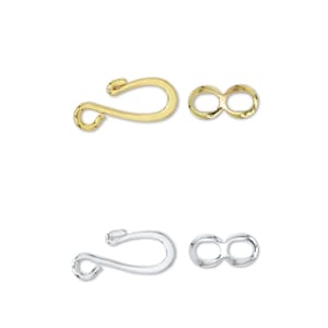 Op de afbeelding: Twee sets gouden en zilveren karabijnhaken en springringen. De karabijnhaken zijn haakvormig en de springringen zijn rond.