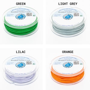 Puede incluir: Cuatro carretes de cord&oacute;n de nailon trenzado en verde, gris claro, lila y naranja. Cada carrete est&aacute; etiquetado con el texto "MULTIPLE USE NYLON CORD" y "Braided Nylon Cord" para joyeros. La marca "GRIFFIN" tambi&eacute;n es visible.