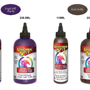 May include: Two bottles of Unicorn Spit gel stain and glaze in two sizes, 118 ml and 236.5 ml. The colors are Purple Hill Majesty, a deep purple, and Rustic Reality, a dark brown.