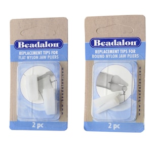 May include: Two packs of white replacement tips for Beadalon pliers. The pack on the left is for flat nylon jaw pliers and the pack on the right is for round nylon jaw pliers. Each pack contains two tips and says "2 pc" on the bottom.