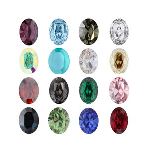 Peut inclure: Assortiment de pierres précieuses ovales de différentes couleurs, notamment rouge, bleu, vert, rose, noir et transparent. Les pierres précieuses sont disposées en trois rangées de quatre.