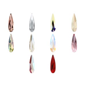 Peut inclure: Une collection de dix cristaux à facettes en forme de goutte d'eau disposés en grille. Les cristaux présentent diverses couleurs, notamment transparent, or rose, irisé, jaune, rose et rouge, chacun avec une pointe et une surface facettée.
