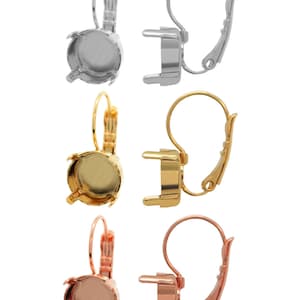 May include: Set of six earring settings in silver, gold, and rose gold. Each setting features a round bezel for a stone and a lever back closure.