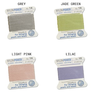 May include: Four spools of nylon power thread for stringing pearls and beads. The colors are grey, jade green, light pink, and lilac. Each spool has the text "Nylon Power" and "No stretch - extra strong" printed on it. The spools are labeled with the thread number and diameter.
