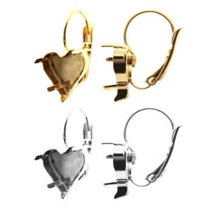 May include: Two pairs of earring settings, one gold and one silver. Each setting is a heart shape with a small opening at the top for attaching a gemstone or other embellishment. The settings are designed to be used with a leverback earring closure.