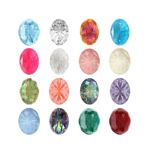Peut inclure: Assortiment de 15 pierres précieuses rondes de différentes couleurs, notamment bleu, rouge, vert, violet et blanc. Les pierres précieuses sont disposées en grille sur un fond blanc.