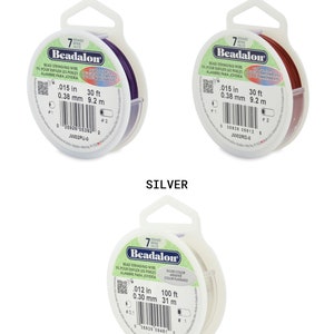 May include: Three spools of Beadalon bead stringing wire. The spools are labeled with the colors purple, red, and silver. Each spool has a label with the wire thickness in inches and millimeters, the length in feet and meters, and the product code.