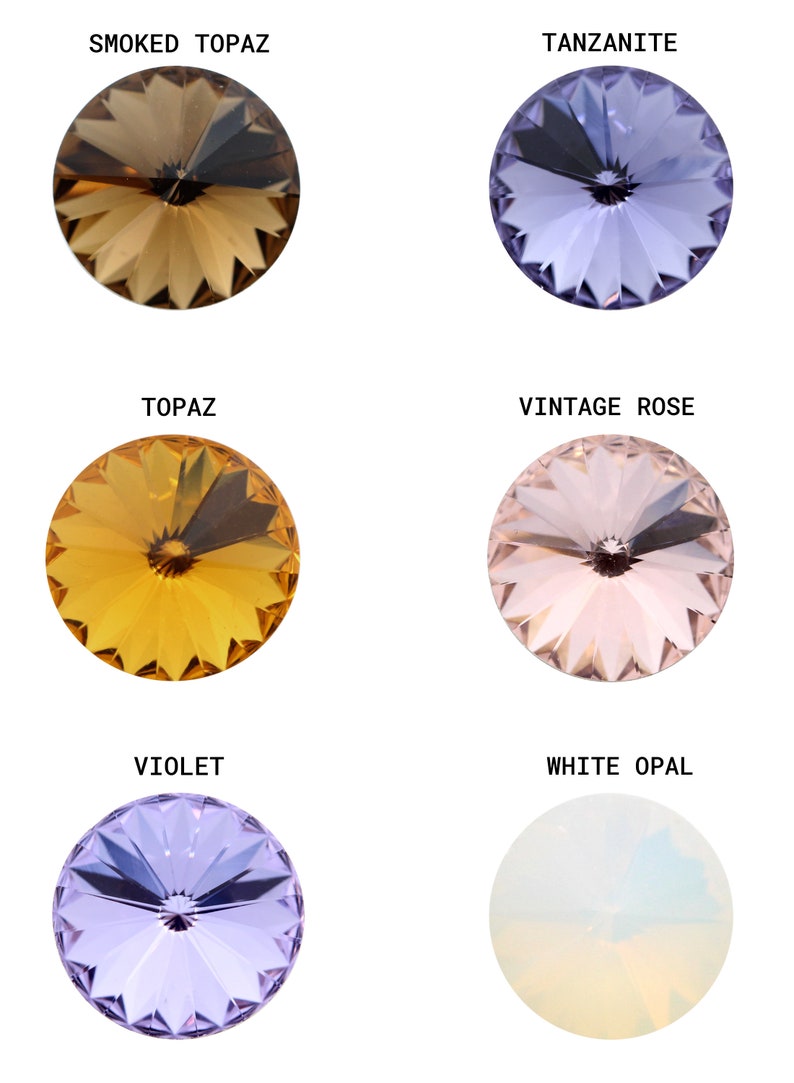 May include: Six round, faceted glass stones in various colors, including smoked topaz, tanzanite, topaz, vintage rose, violet, and white opal. Each stone has a small, clear center.
