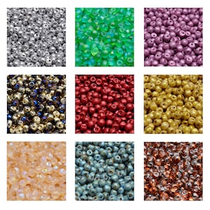 May include: Assortment of glass beads in various colors and finishes, including silver, green, purple, gold, red, blue, and brown. The beads are all round and have a smooth surface.
