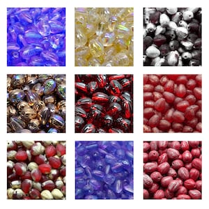 Puede incluir: Colección de cuentas ovaladas en varios colores, incluyendo azul, amarillo, blanco y negro, dorado y rojo. Las cuentas tienen un acabado brillante e iridiscente, adecuadas para la fabricación de joyas y manualidades.