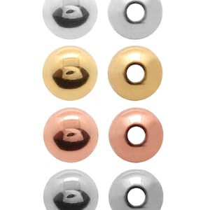 May include: Eight round beads in different metal finishes: silver, gold, and rose gold. Each bead has a hole in the centre.