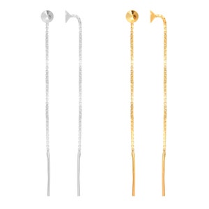 Può includere: Due paia di orecchini lunghi e sottili a catena. Un paio è d'argento e l'altro è d'oro.