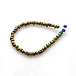 May include: A green iridescent beaded bracelet with a silver clasp and blue accent beads.