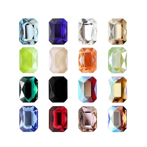 Peut inclure: Assortiment de 18 pierres précieuses en verre taille émeraude de différentes couleurs, notamment bleu, vert, rouge, orange et noir. Les pierres précieuses sont disposées en trois rangées de six.