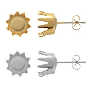 May include: Two pairs of earring settings, one gold and one silver. Each setting has a crown-shaped base and a round top with a smooth surface. The settings are designed to hold a gemstone or other embellishment.