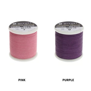 Op de afbeelding: Twee spoelen Miyuki Beading Thread, &eacute;&eacute;n roze en &eacute;&eacute;n paars. De spoelen zijn gelabeld met de merknaam, het type draad en het kleurnummer. De roze spoel is gelabeld "BF05R 7" en de paarse spoel is gelabeld "YHO1R 9".