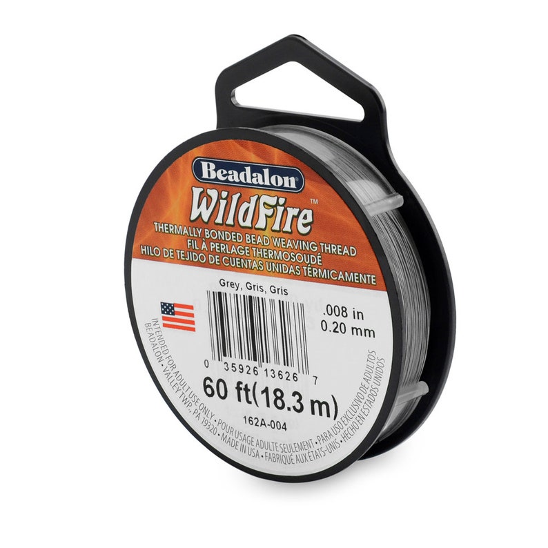 May include: A spool of gray Beadalon WildFire thermally bonded bead weaving thread. The spool is labeled with the brand name, product name, and details about the thread, including the size, length, and material. The label also includes a barcode and the text "Made in USA."