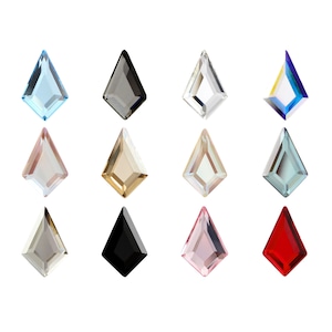 Pode incluir: Doze strass de vidro facetados em várias cores, incluindo transparente, preto, vermelho, azul e dourado. Os strass estão dispostos em três filas de quatro.
