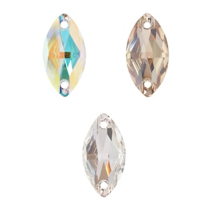 May include: Three crystal rhinestones in a marquise shape with two holes for sewing. The rhinestones are in the colors clear, light topaz, and light sapphire.