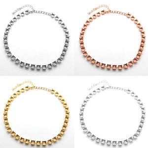May include: Four silver, gold, rose gold, and white metal choker necklaces with a square-shaped rhinestone design.