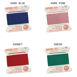 May include: Four spools of natural silk thread for stringing pearls and beads. The colors are dark blue, dark pink, garnet red, and green. Each spool is labeled "Natural Silk" and has the number 10 and the diameter 0.90 mm printed on it.