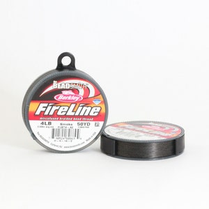 Puede incluir: Una bobina de hilo de cuentas trenzado microfusionado Berkley FireLine en color humo. La bobina es de 50 yardas y 4 lb. La etiqueta tambi&eacute;n dice "The Beadsmith" y "Made in USA".