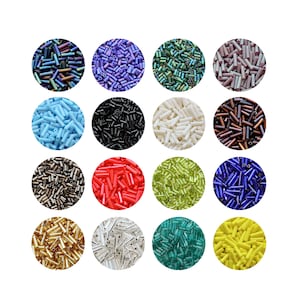 Könnte beinhalten: Eine Sammlung farbenfroher Glas-Saatperlen in verschiedenen Farben, darunter Blau, Lila, Grün, Rosa, Schwarz, Weiß, Braun, Rot, Limettengrün, Dunkelblau, Gold, Silber, Türkis und Gelb. Jede Farbe ist in einer kreisförmigen Form enthalten.