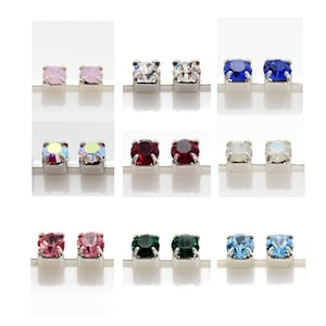 May include: Assortment of 10 pairs of small, silver stud earrings with various coloured rhinestones. The colours include pink, white, blue, red, green, and light blue.