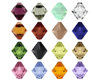 Op de afbeelding: Assortiment van 16 gefacetteerde glazen kralen in verschillende kleuren, waaronder paars, groen, lichtblauw, helder, oranje, bruin, zwart en geel. De kralen zijn vierkant met puntige hoeken.